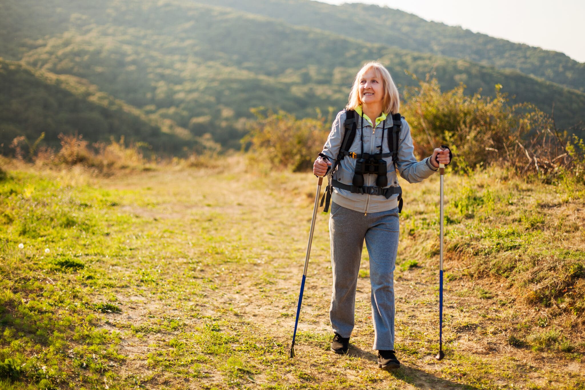 Senior woman is hiking in mountain.