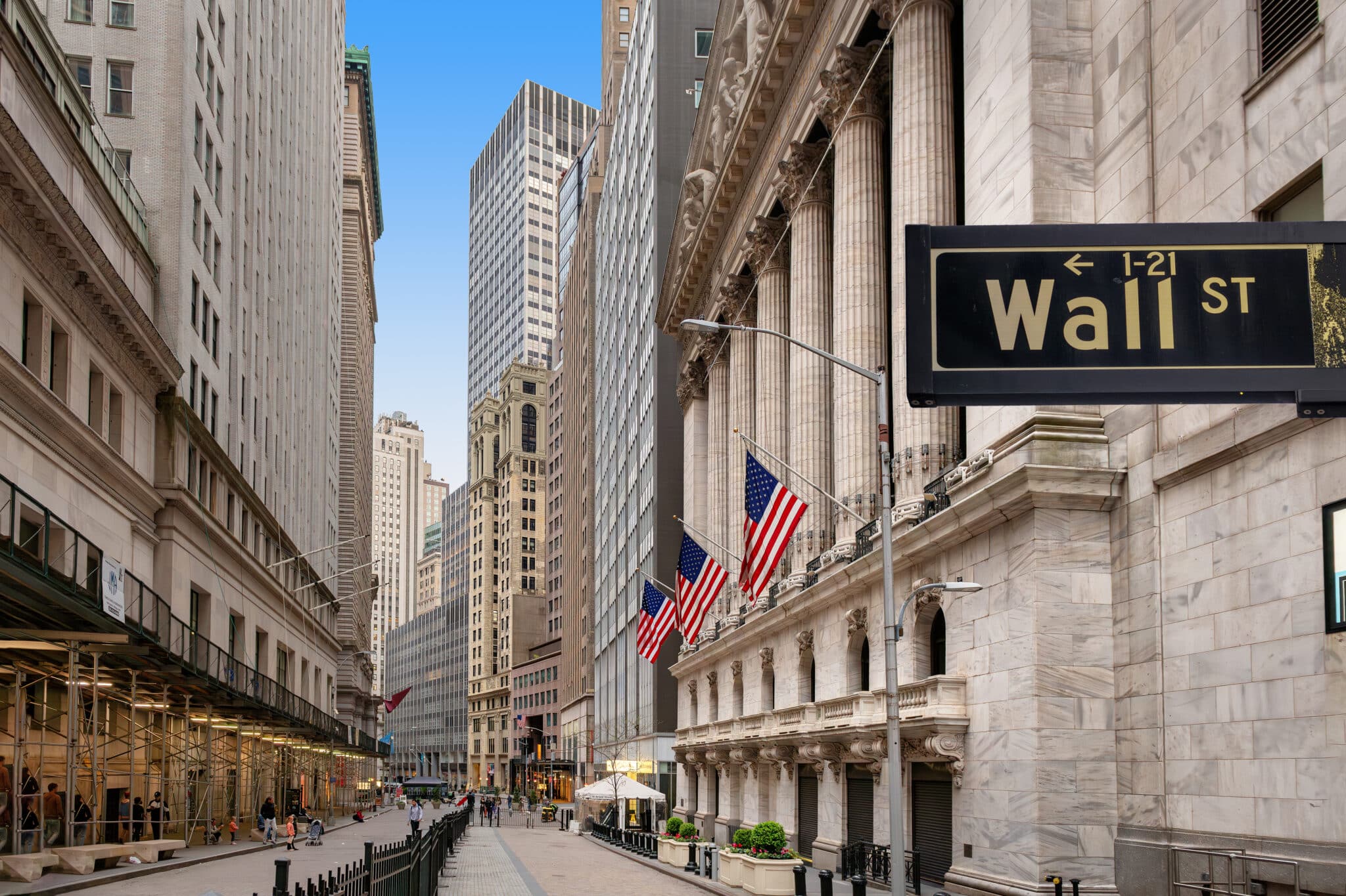 A long view of the Wall Street along with the street sign with the same name.